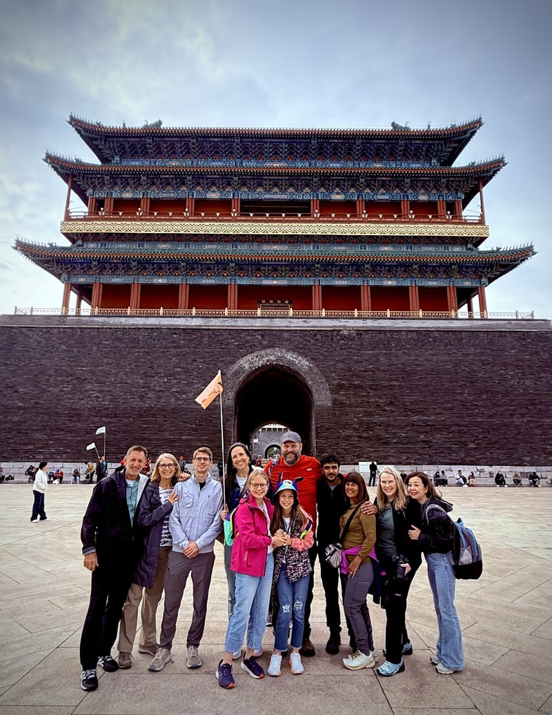 A group of travelers in front of a city gate tower