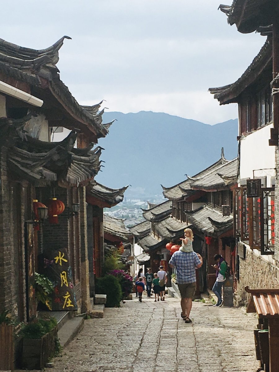 Walking the stone streets of Lijiang Old Town, with the mountains beyond