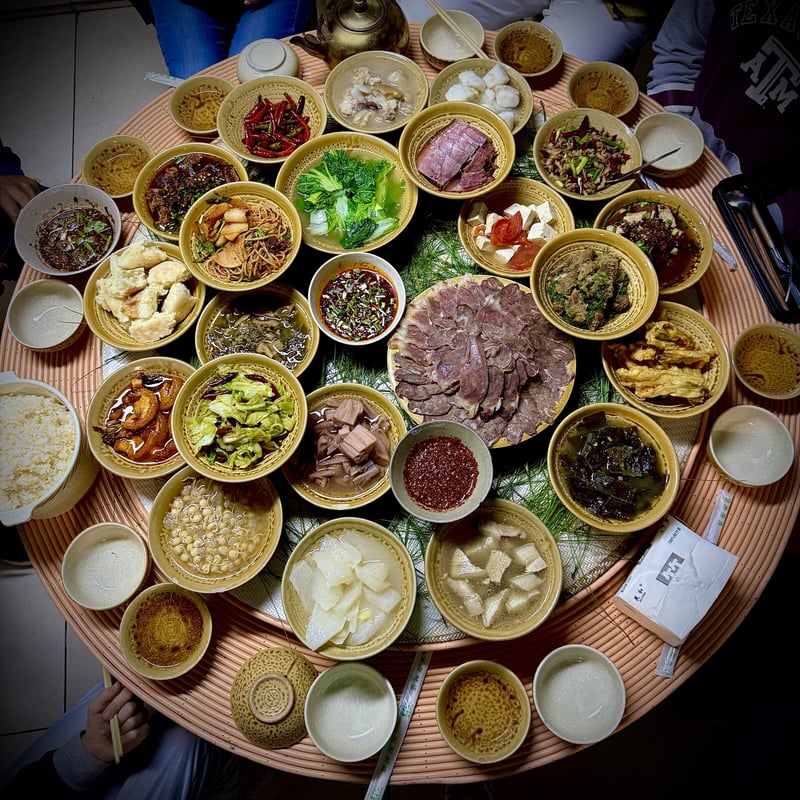 A round table covered with small dishes of Yunnan food