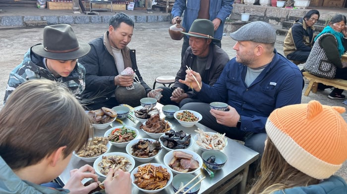 Travelers sharing a village meal in Yunnan